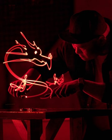 Jaeger-LeCoultre - Made of Makers Roy Wang working on a light painting with a red dragon above a Reverso watch