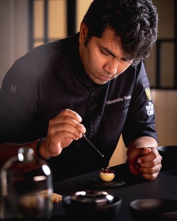 Jaeger-LeCoultre - Precision Pioneer Exhibition booth in Dubai with Chef Himanshu Saini cooking and preparing its creation "Pine Nut Delight"